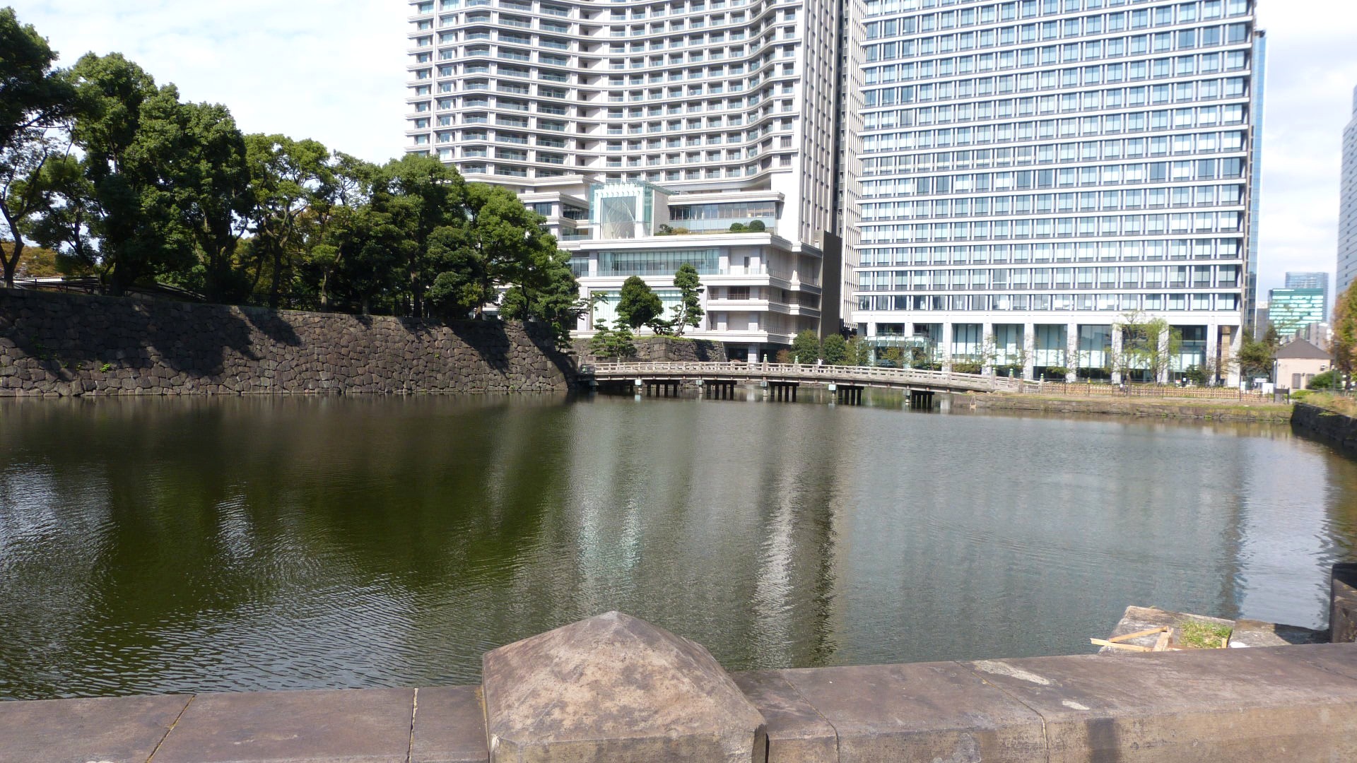 water-filled moat with tall modern buildings in the background